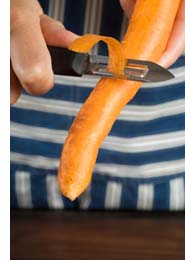 person peeling a carrot