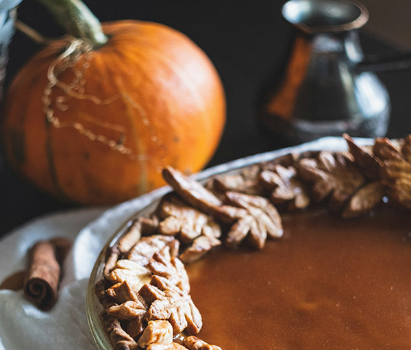 Pumpkin pie with pumpkin in the background