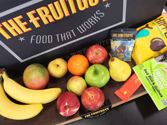 fruit and snacks surrounding a Fruitguys box