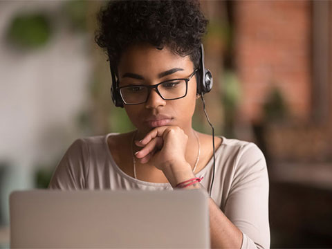 Woman with headphones working on computer