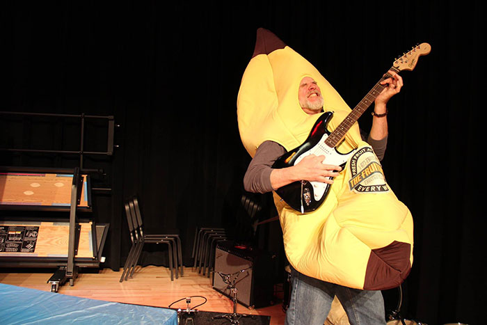 Man playing guitar in banana suit