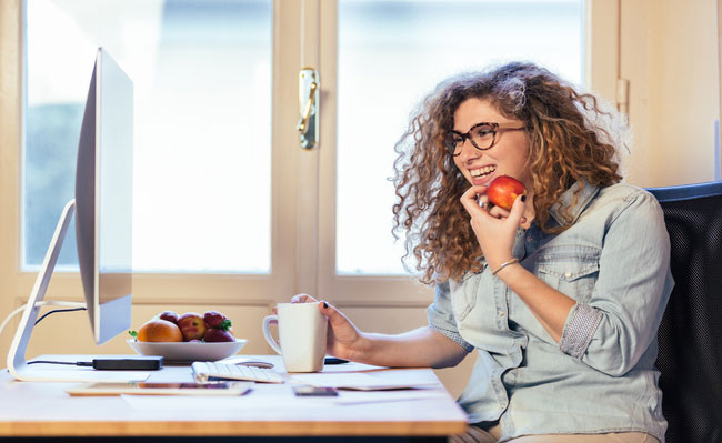 Photo: remote female employee smiling with apple