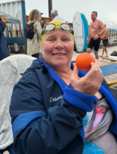 24-Hour Relay Swimmer holding a Murcott tangerine from Fruit World