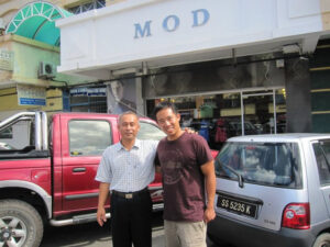 Two men in front of a shop