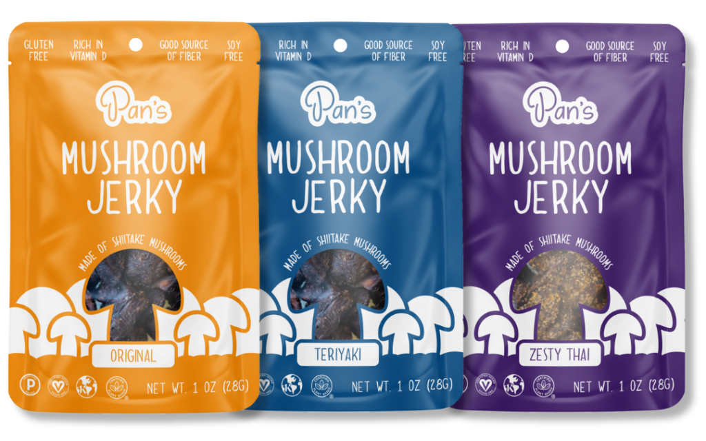 AAPI-owned snacks: Pan's Mushroom Jerky in three flavors, Original, Teriyaki, and Zesty Thai. Packaging reads "Gluten Free, Rich in Vitamin D, Good Source of Fiber, Soy Free, Made of Shiitake Mushrooms, Net Wt. 1 oz (28G)"