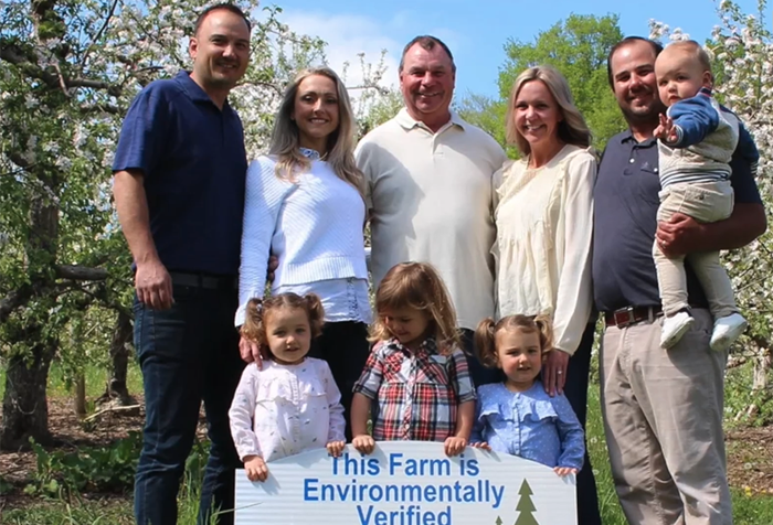 Klüg family gathered around a "This Farm is Environmentally Verified" sign