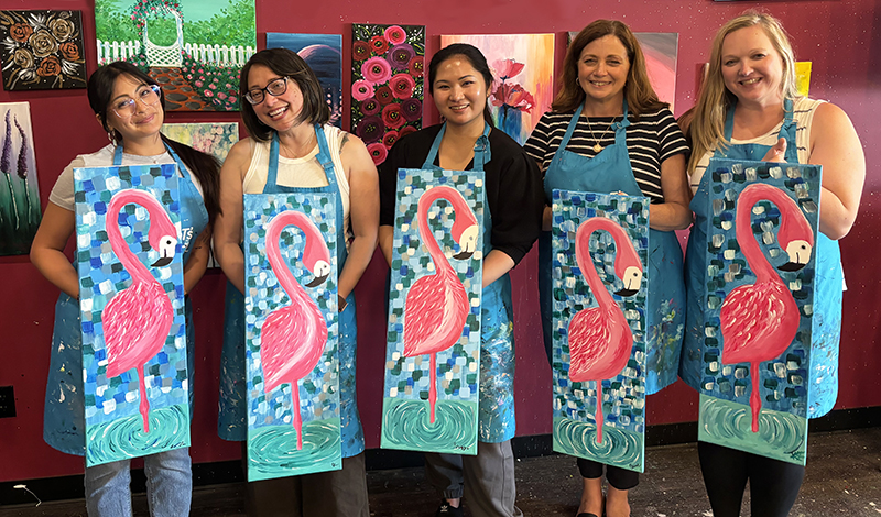 School team holding flamingo paintings