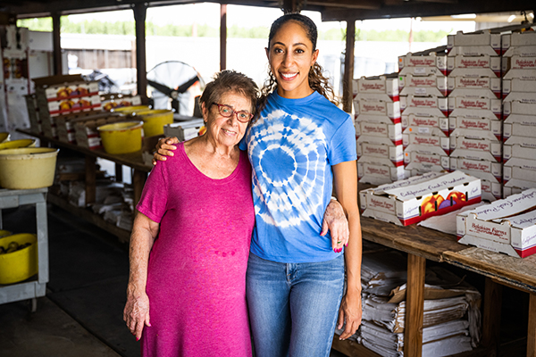 Grandmother and granddaughter in fruit packing house