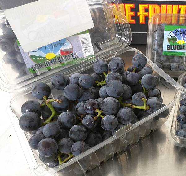 Concord grapes in front of a The FruitGuys box