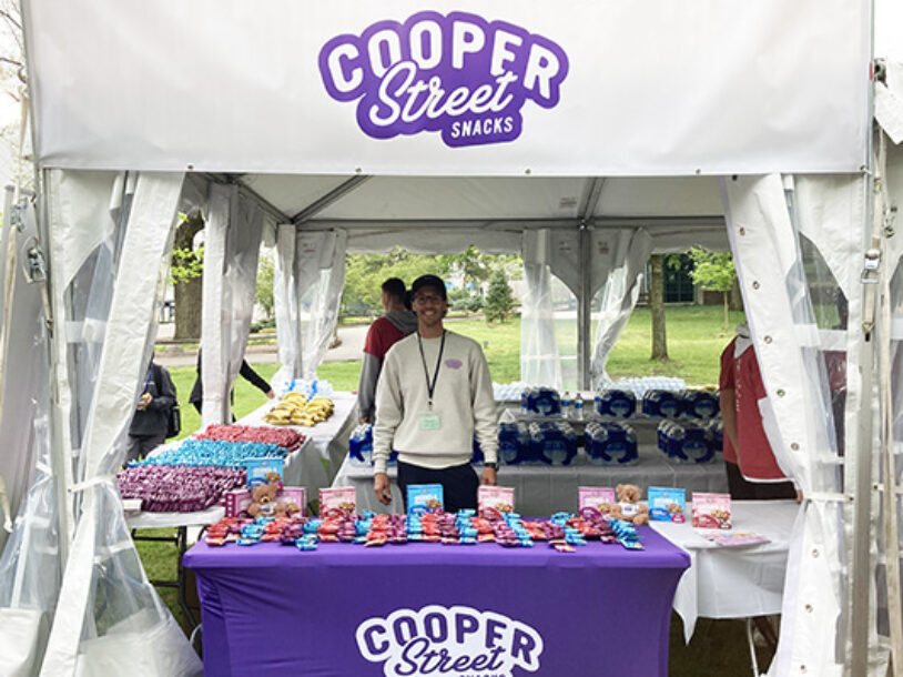 Cooper Street Snacks booth full of Granola Bakes, Thank You To Our Joy Sponsor on booth banner