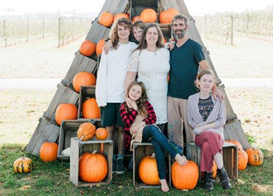 Family photo, parents and four children in a pumpkin patch