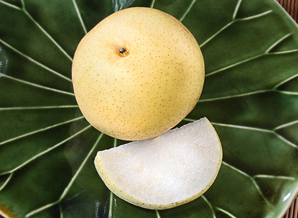 Whole pear and pear slice on plate