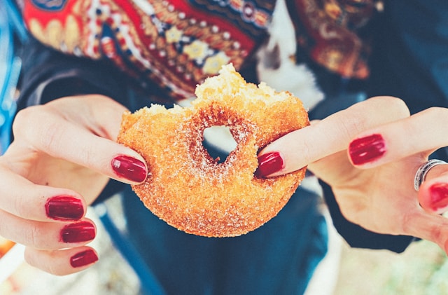 Woman holding half-eaten donut