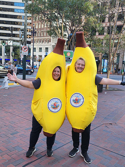 Two smiling women in banana suits