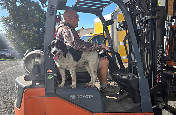 Man and dog on forklift