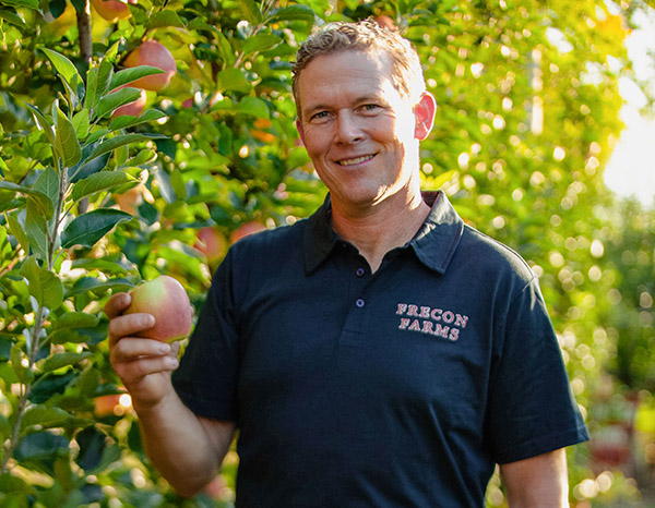 Smiling man picking apple