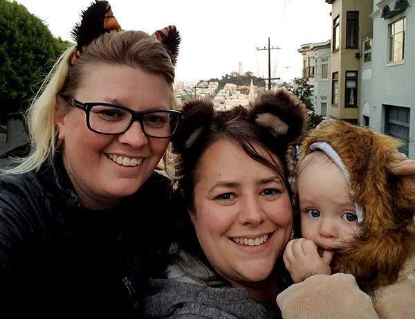 Parents and child in tiger, bear, and lion Halloween costumes