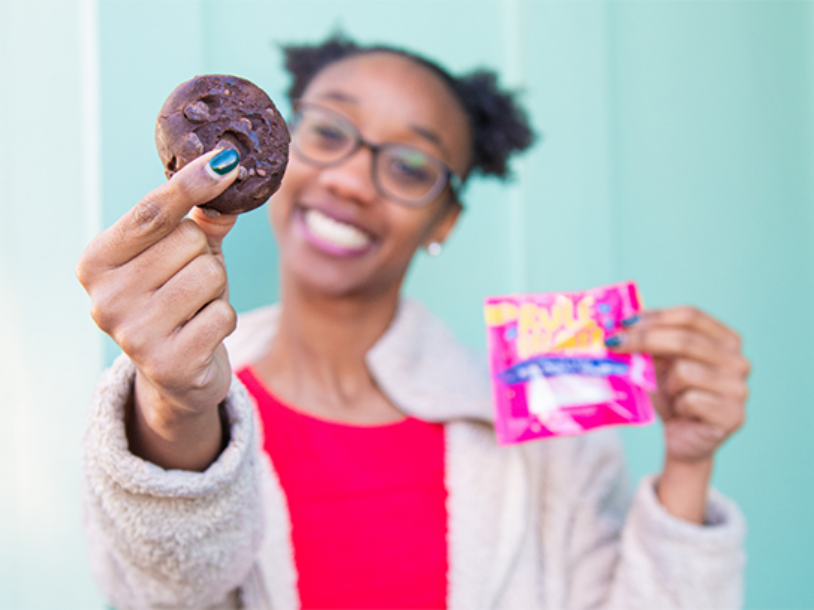 Woman holding sweet healthy snack and Rule Breaker packaging