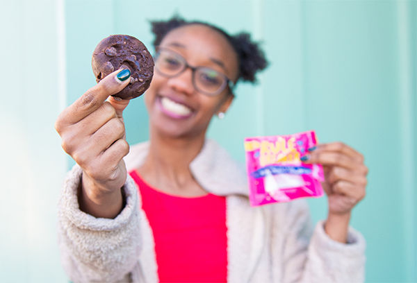 Woman holding cookie and packaging