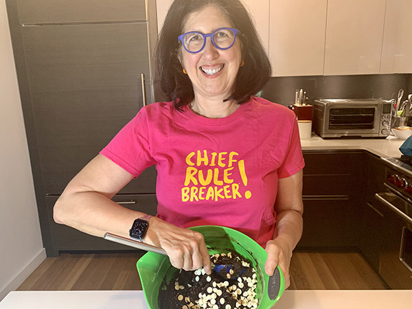 Woman making brownies, her shirt reads "Chief Rule Breaker!"