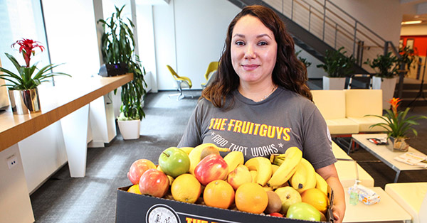 Woman holding box of fruit