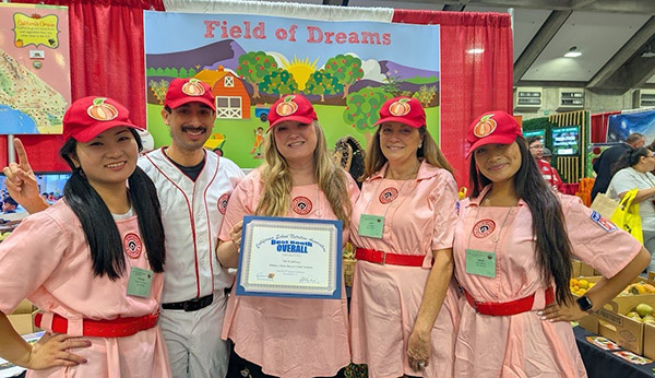 School team holding Best Overall Booth award; Field of Dreams banner in the background