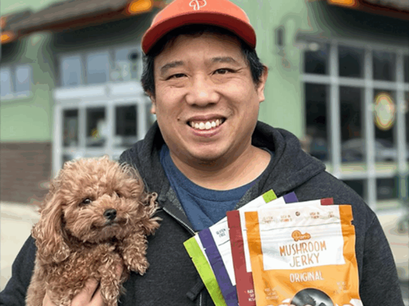 Man holding dog and Pan's Mushroom Jerky, Original and other flavors