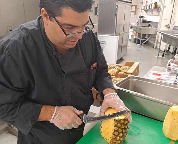 Man slicing pineapple