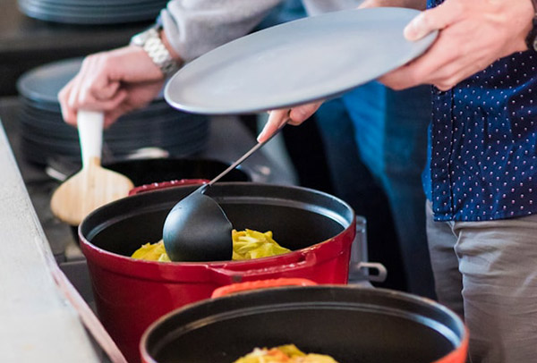 Workers serving themselves food at a potluck