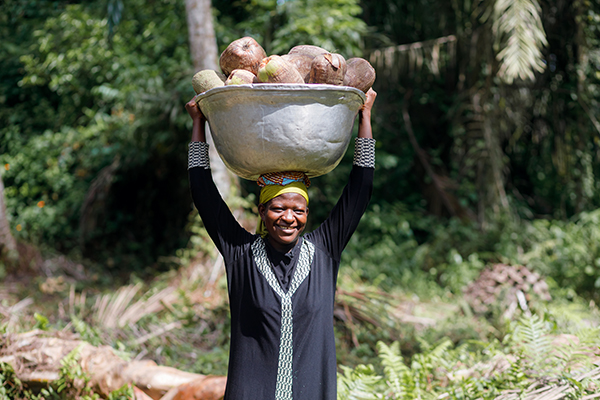 Woman carrying a basket of coconuts on her head