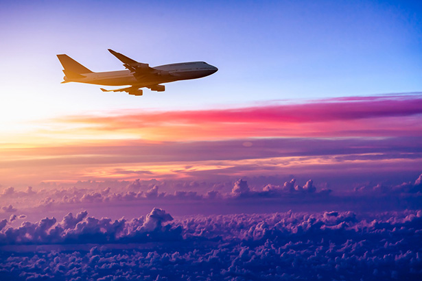 Airplane flying through a colorful sunrise