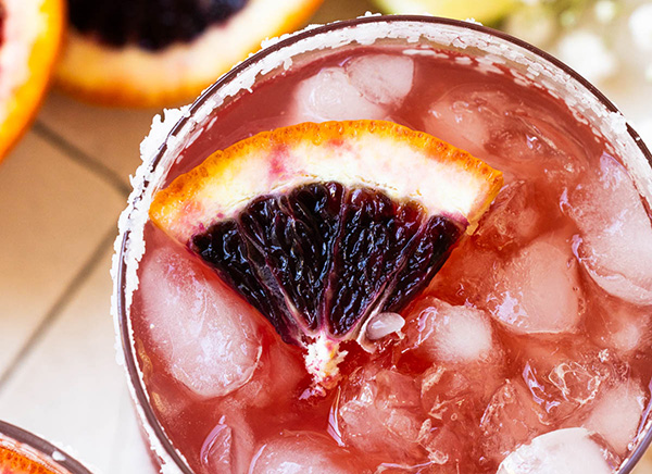 Slice of fresh blood orange floating in cocktail