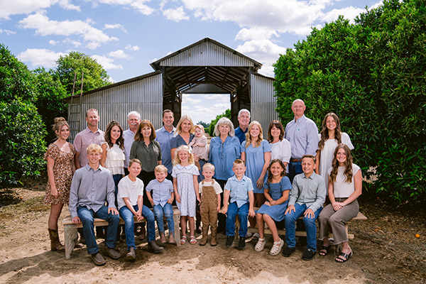 Smiling family standing in front of a barn