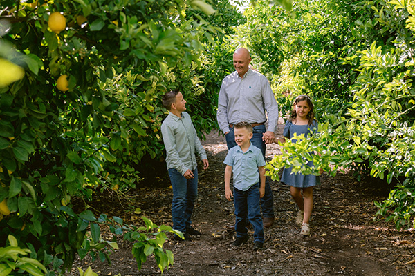 Smiling man and kids in lemon grove