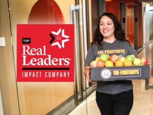 Smiling woman delivering fruit; 2025 Real Leaders Top Impact Company badge