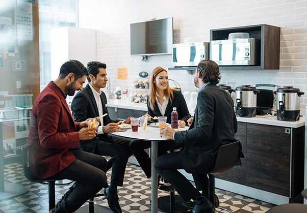 group of employees chatting in front of office snack station