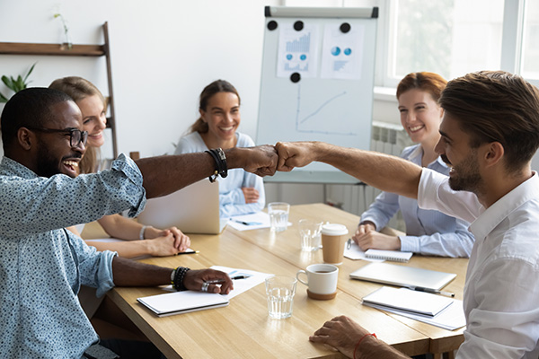 Smiling coworkers fistbumping