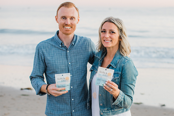 Smiling couple holding sustainable corporate snacks