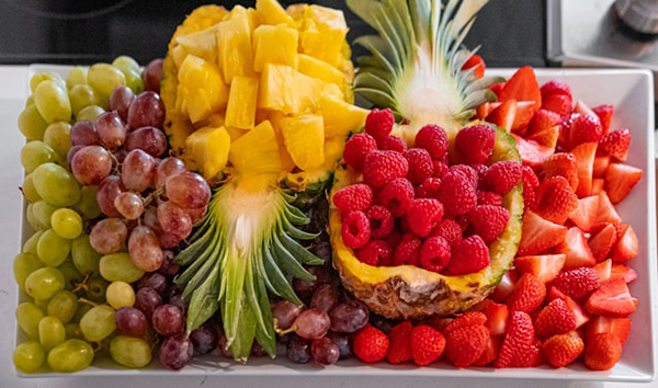 Fruit platter with halved pineapple filled with fruit