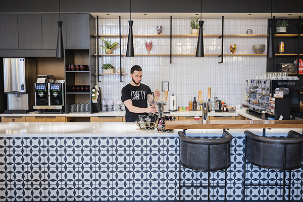 Man in office kitchen making a drink
