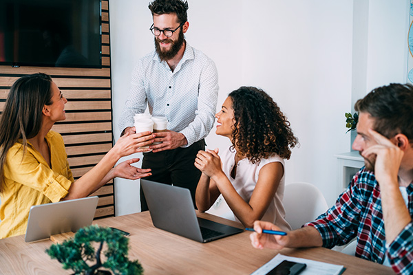 Man handing out coffee to employees at work as a form of appreciation