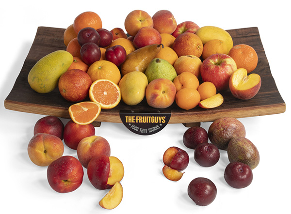 Wooden tray with The FruitGuys logo full of seasonal fresh fruit