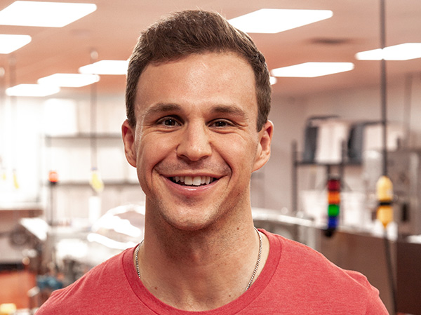 Man smiling at the camera in a food manufacturing facility