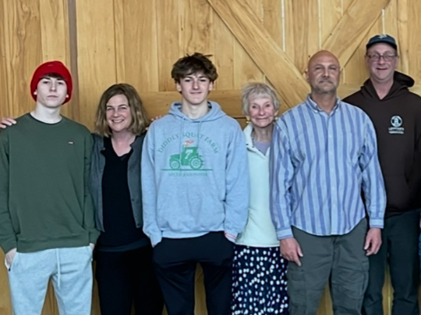 Family posing for a photo in front of a wooden wall