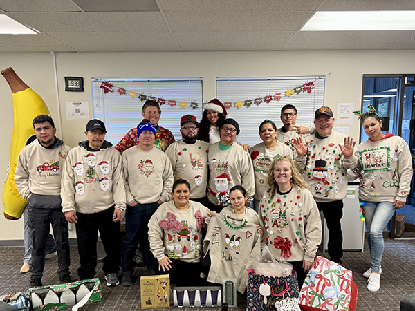 Group of employees in Christmas sweaters in the office