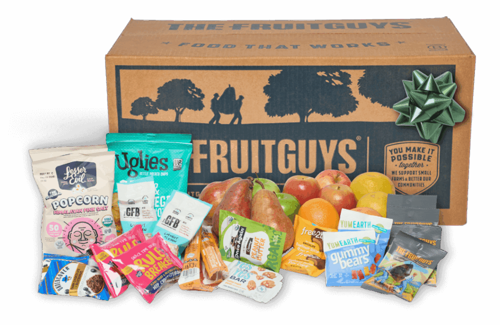 The FruitGuys box with bow surrounded by fruit and snacks