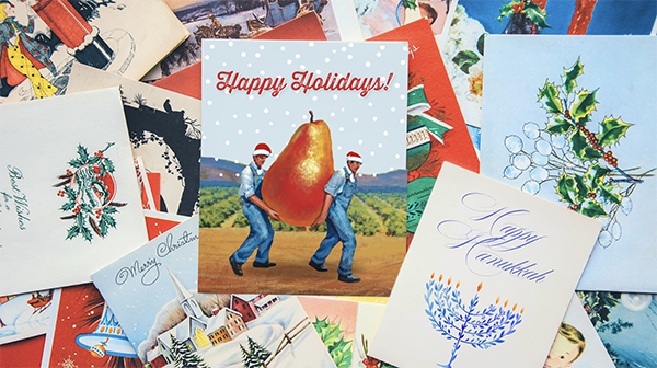 Overlapping pile of holiday cards, card from The FruitGuys in the center that says Happy Holidays