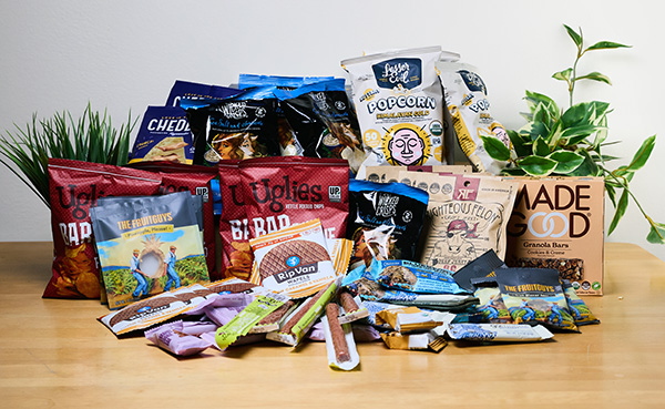 Assortment of packaged snacks on a table, including Whims