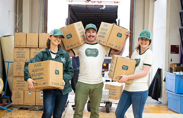 smiling people holding boxes of donations