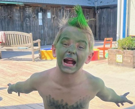 Boy with green hair and skin snarling